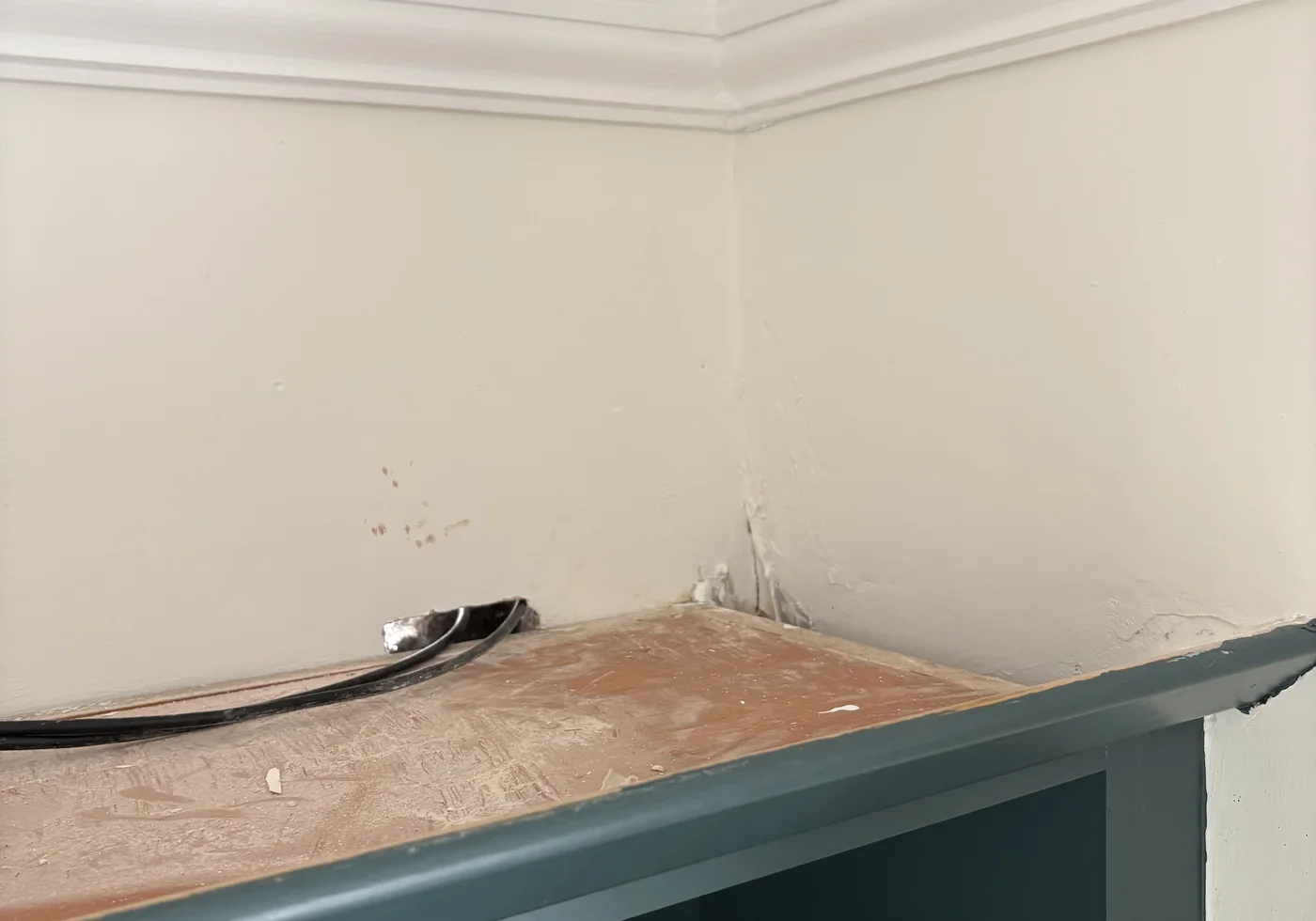 Cat6 cables passing through a small wall opening above the fitted cabinet in Niall’s home