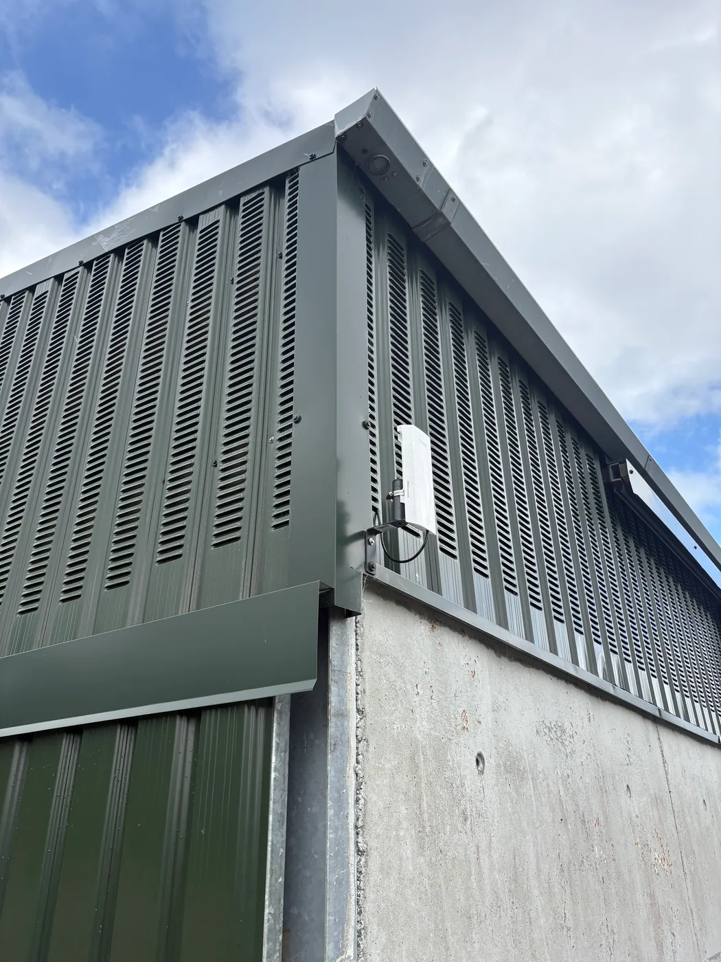 Point-to-point wireless bridge mounted on a bracket on the outside of Peter’s barn